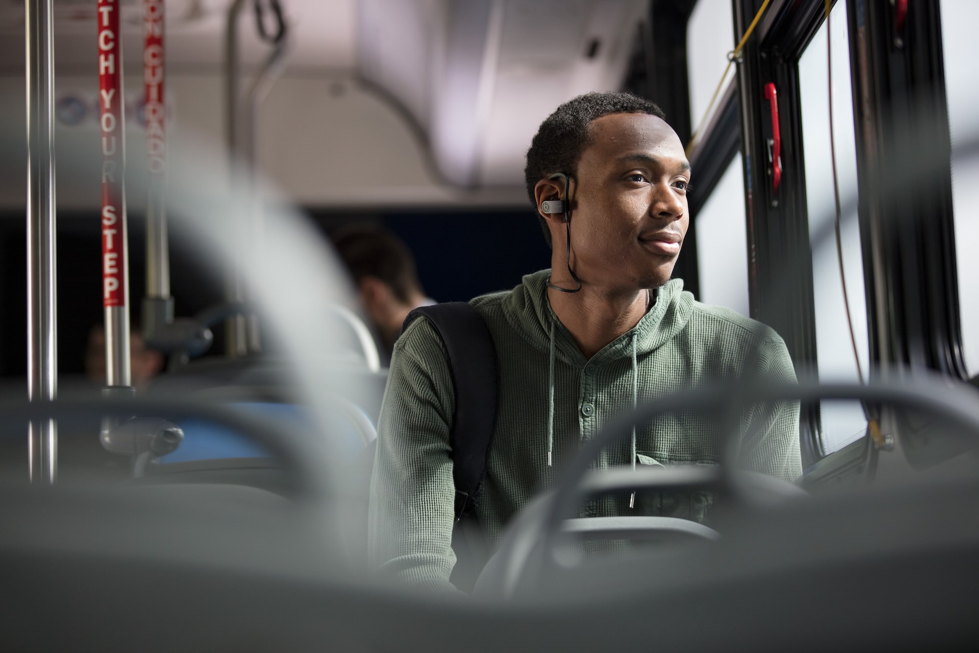 man on a bus listening to music on a headset