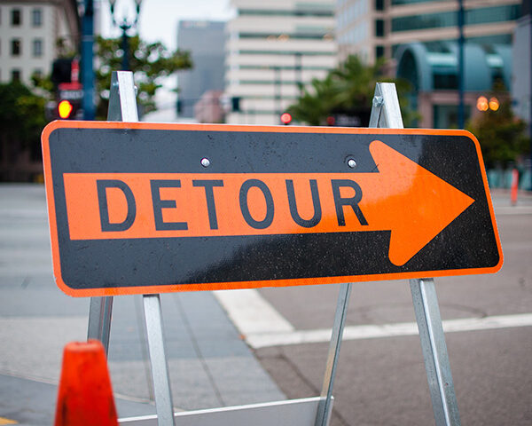 A detour sign directs traffic onto another street