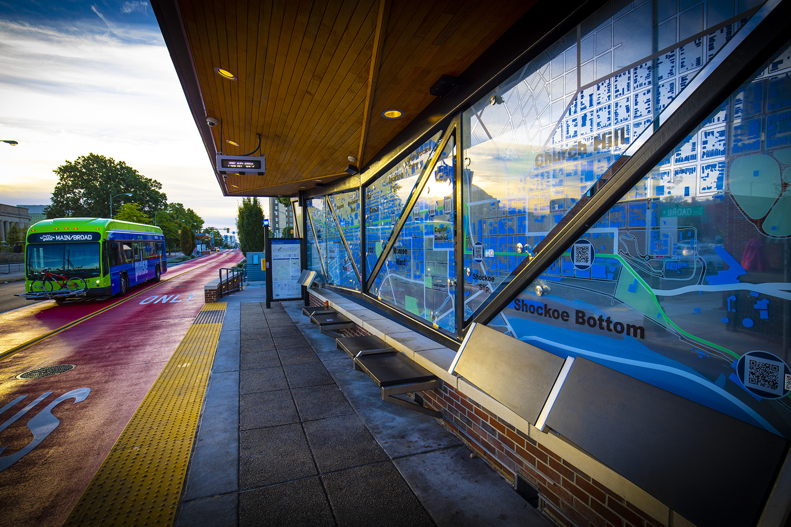 A colorful bus shelter with neighborhoods labeled