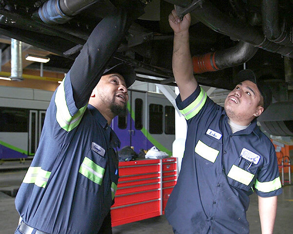 Mechanics working underneath a bus