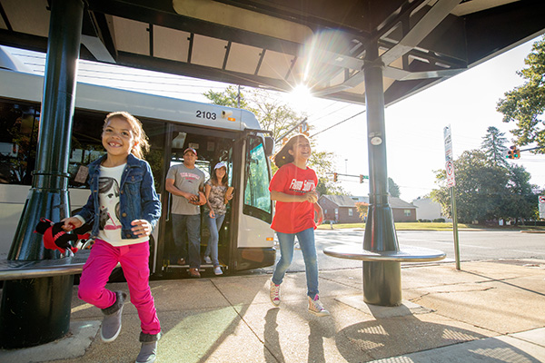 A happy family exits the bus at their destination.