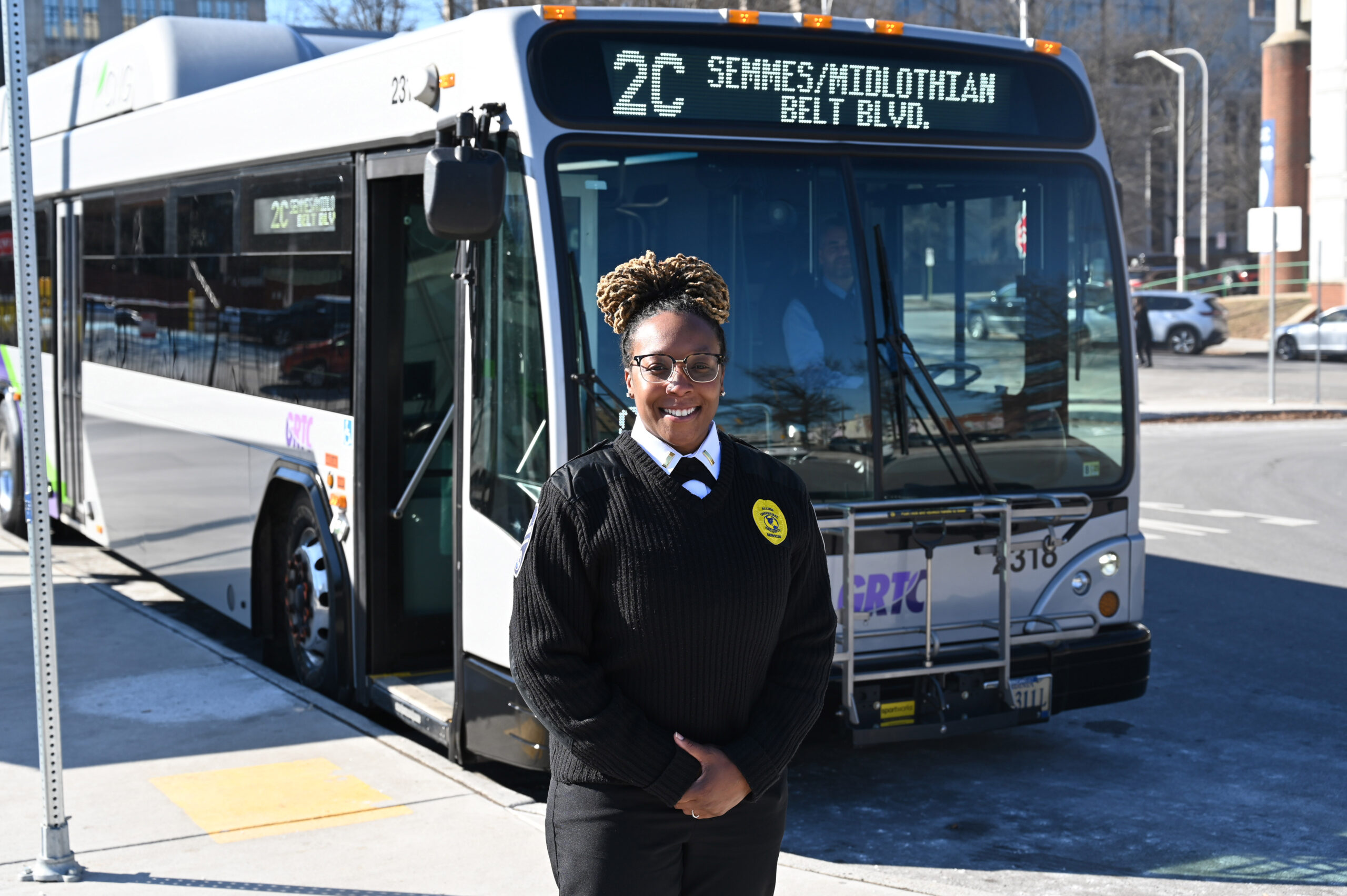 Public Safety Officer at the Downtown Transfer Center in front o 2 C bus