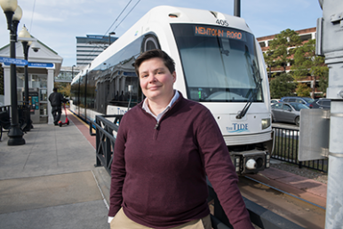 Sam Sink standing in front of an HRT Tide light rail vehicle