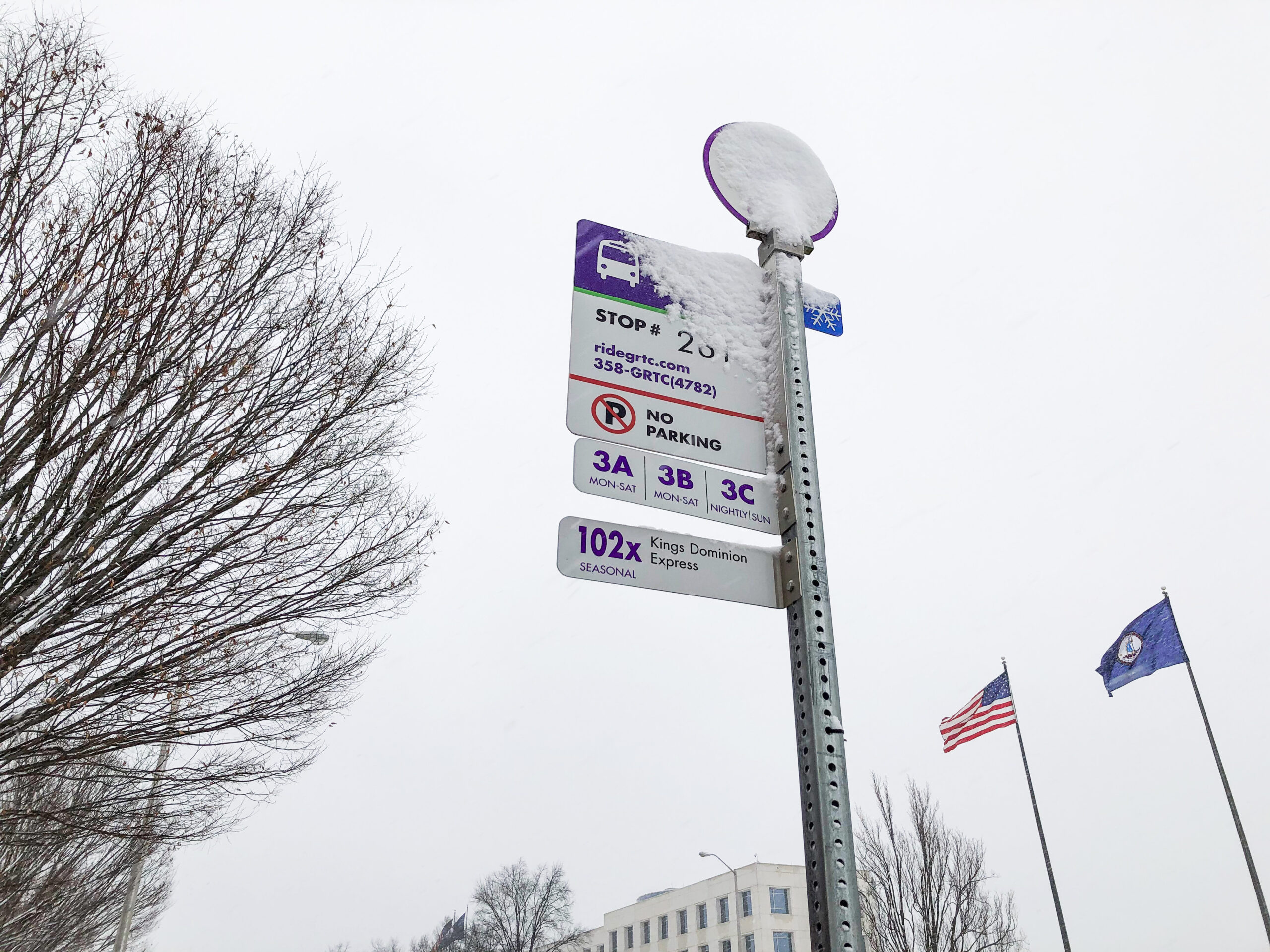 snow on a bus stop sign