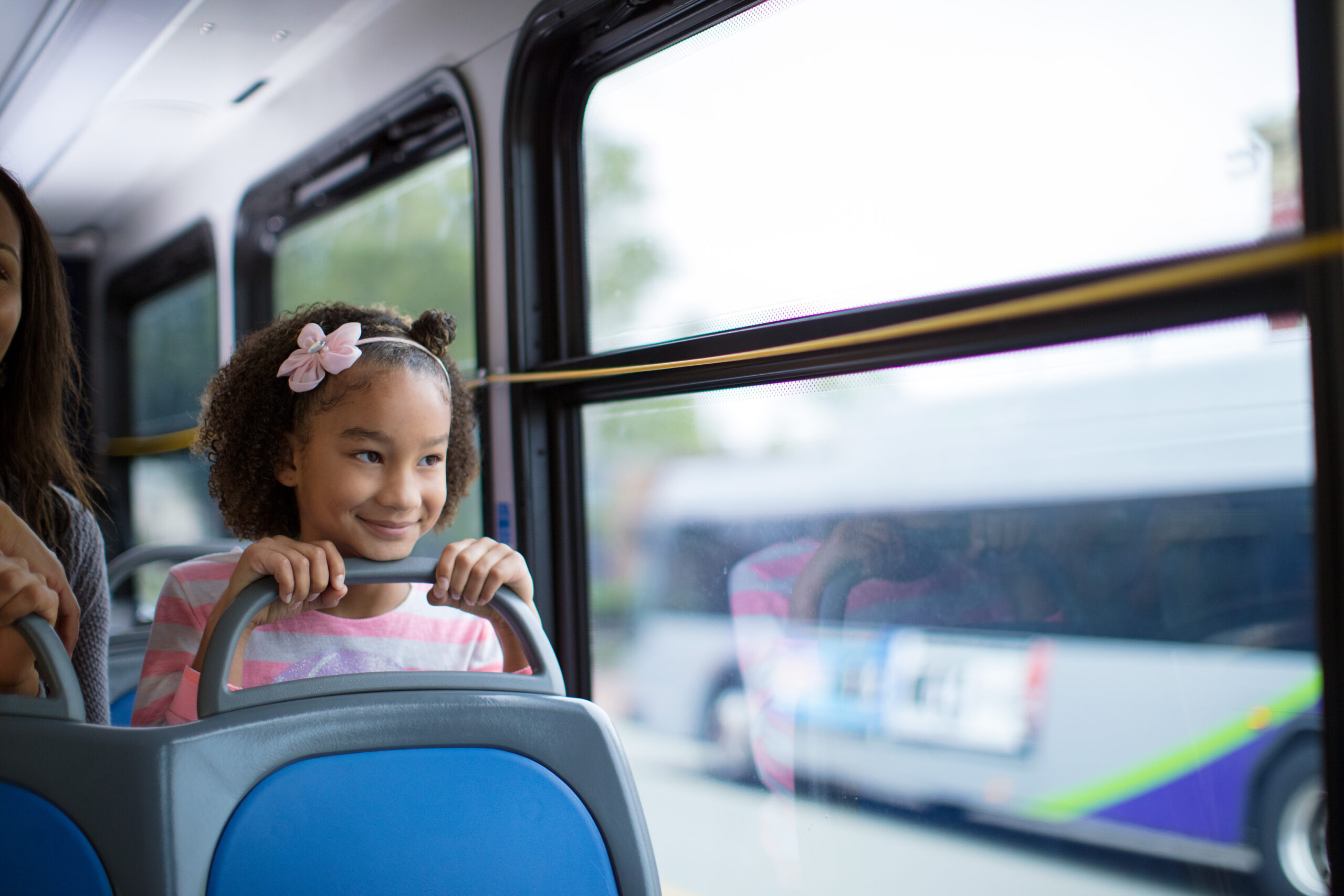 a young girl riding GRTC bus and looking out the window